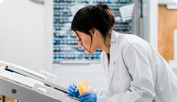 A young female pharmacist sorting and packaging medication at work