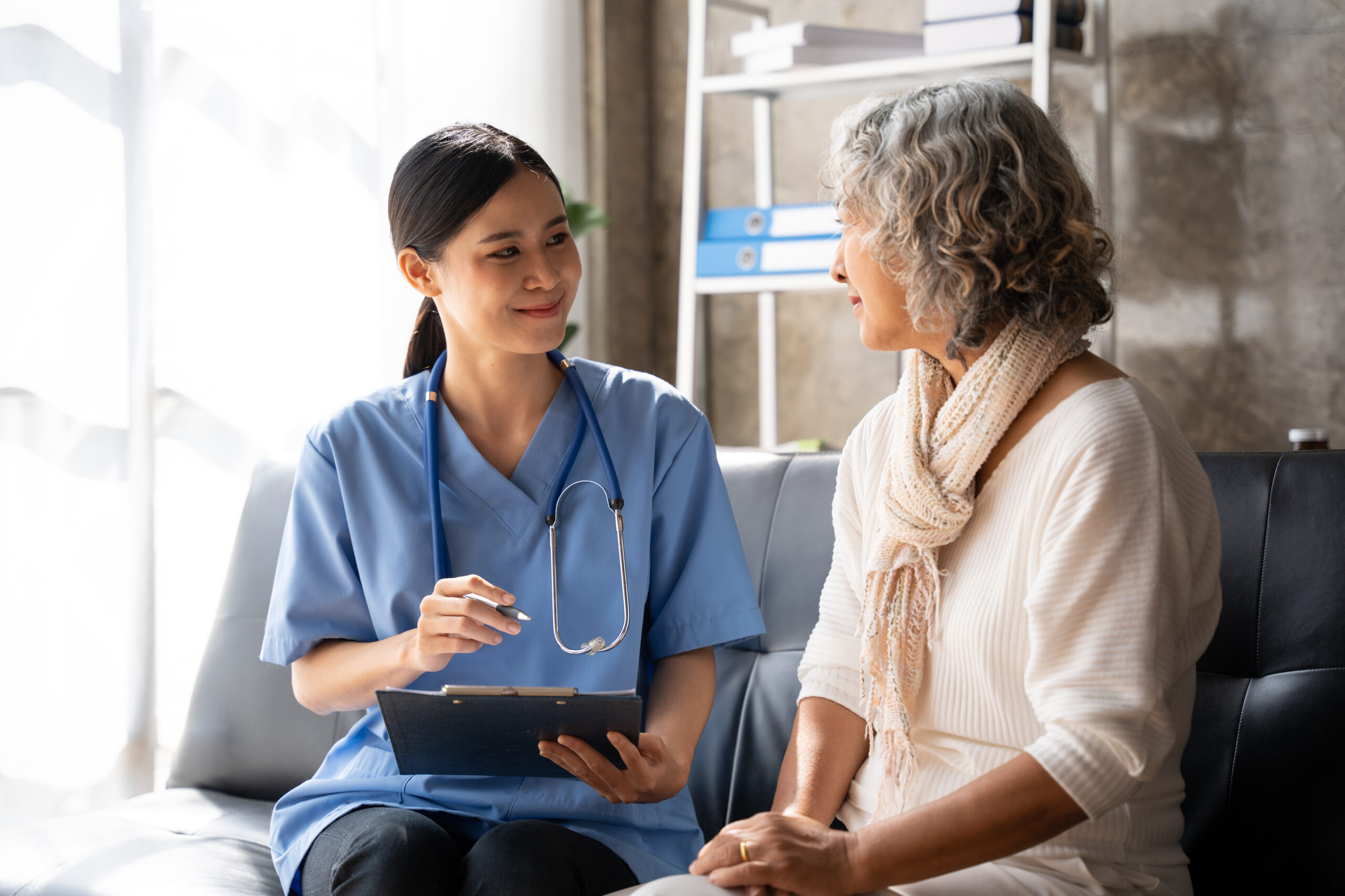 Asian young nurse supporting elderly patient disabled woman in hospital. Elderly patient care concept.