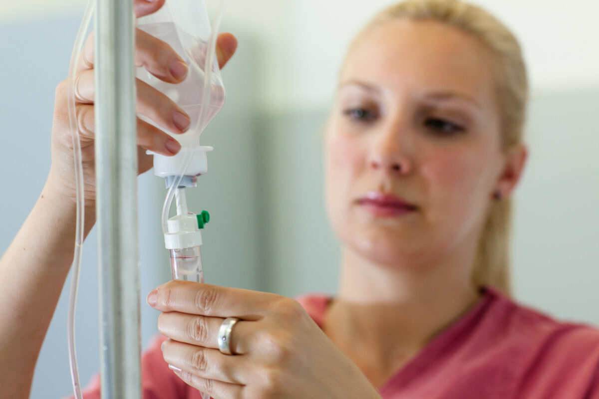 Blond female nurse prepares an IV Drip