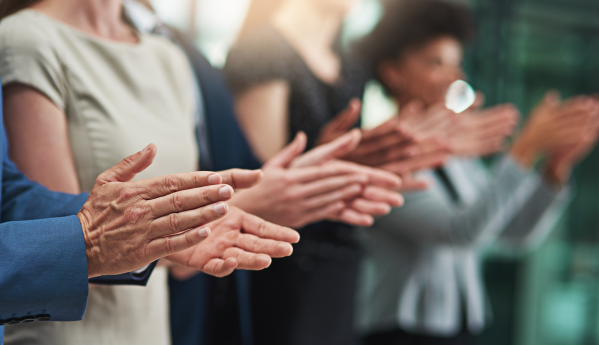People clapping in a line, emphasizing their hands in motion.
