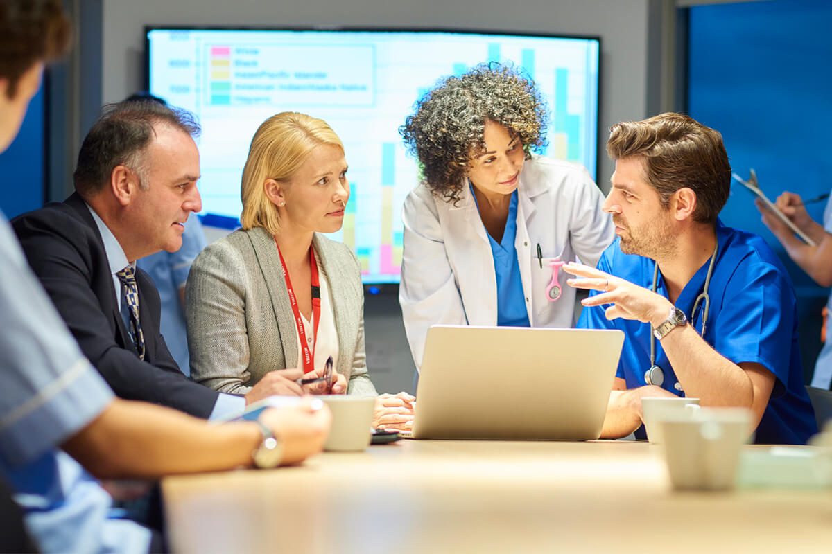 Business and medical professionals talking around a conference table