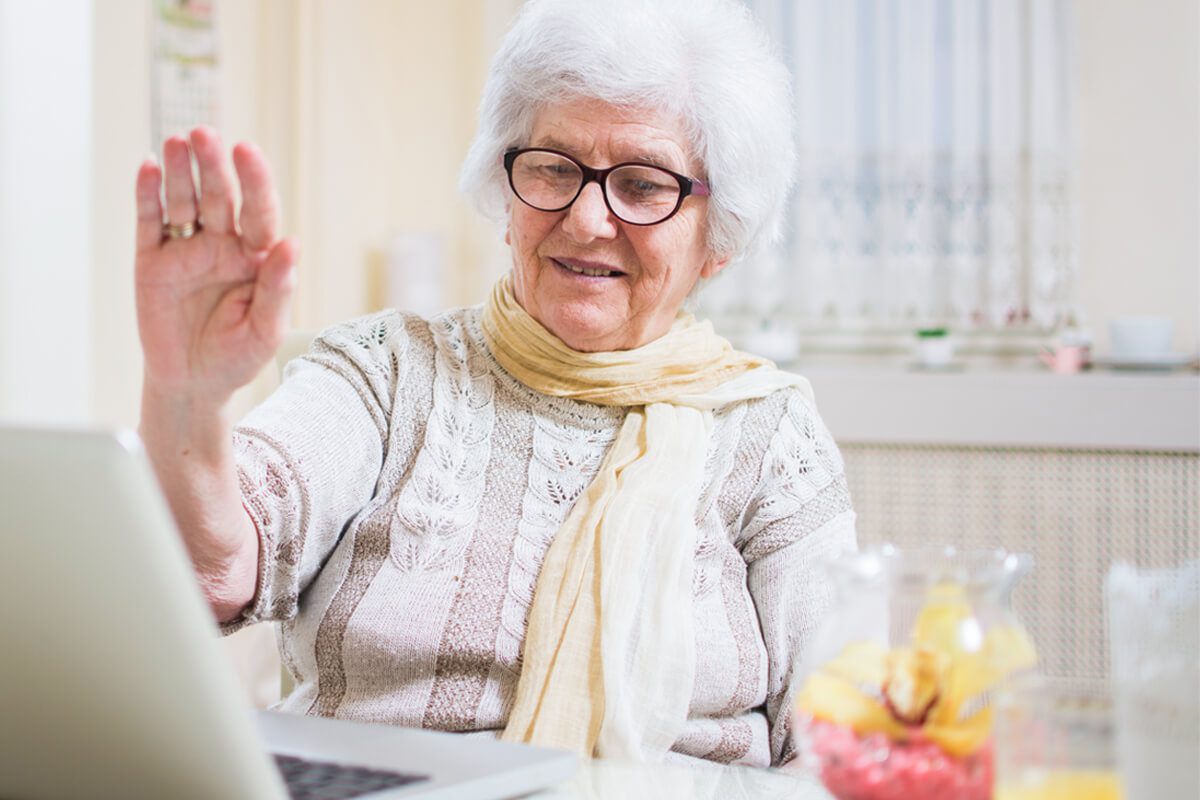 An older woman interacting with a laptop computer